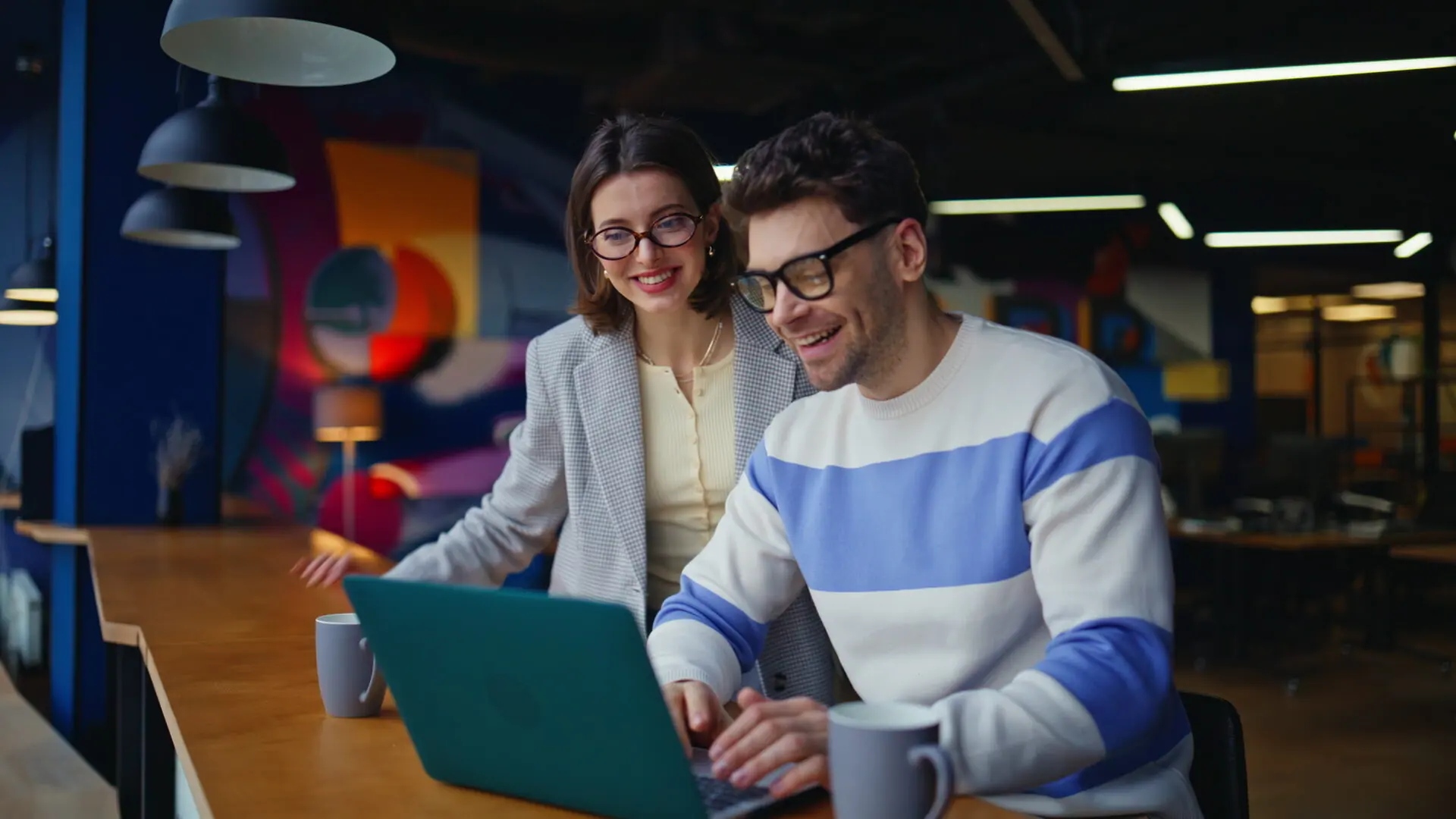 Two colleagues reviewing campaign results on a laptop